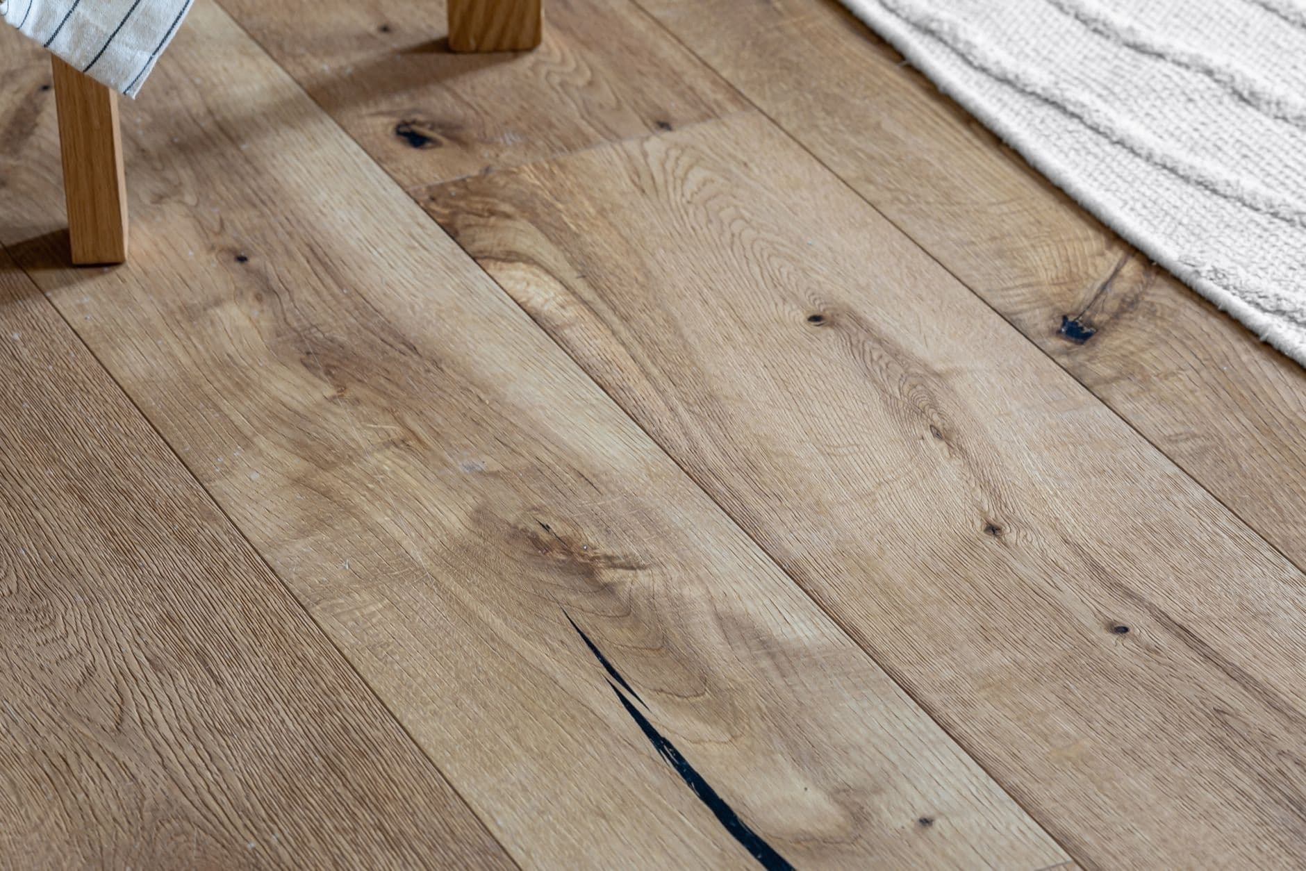 A woven rug meeting bare wooden plank flooring
