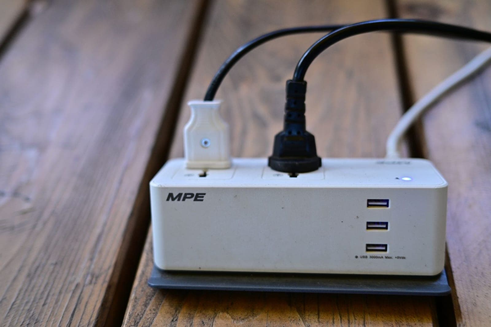 Charging cables and a power strip on a wooden surface