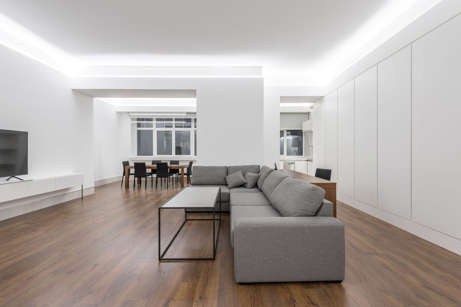 A living room with a gray sofa and a wooden floor