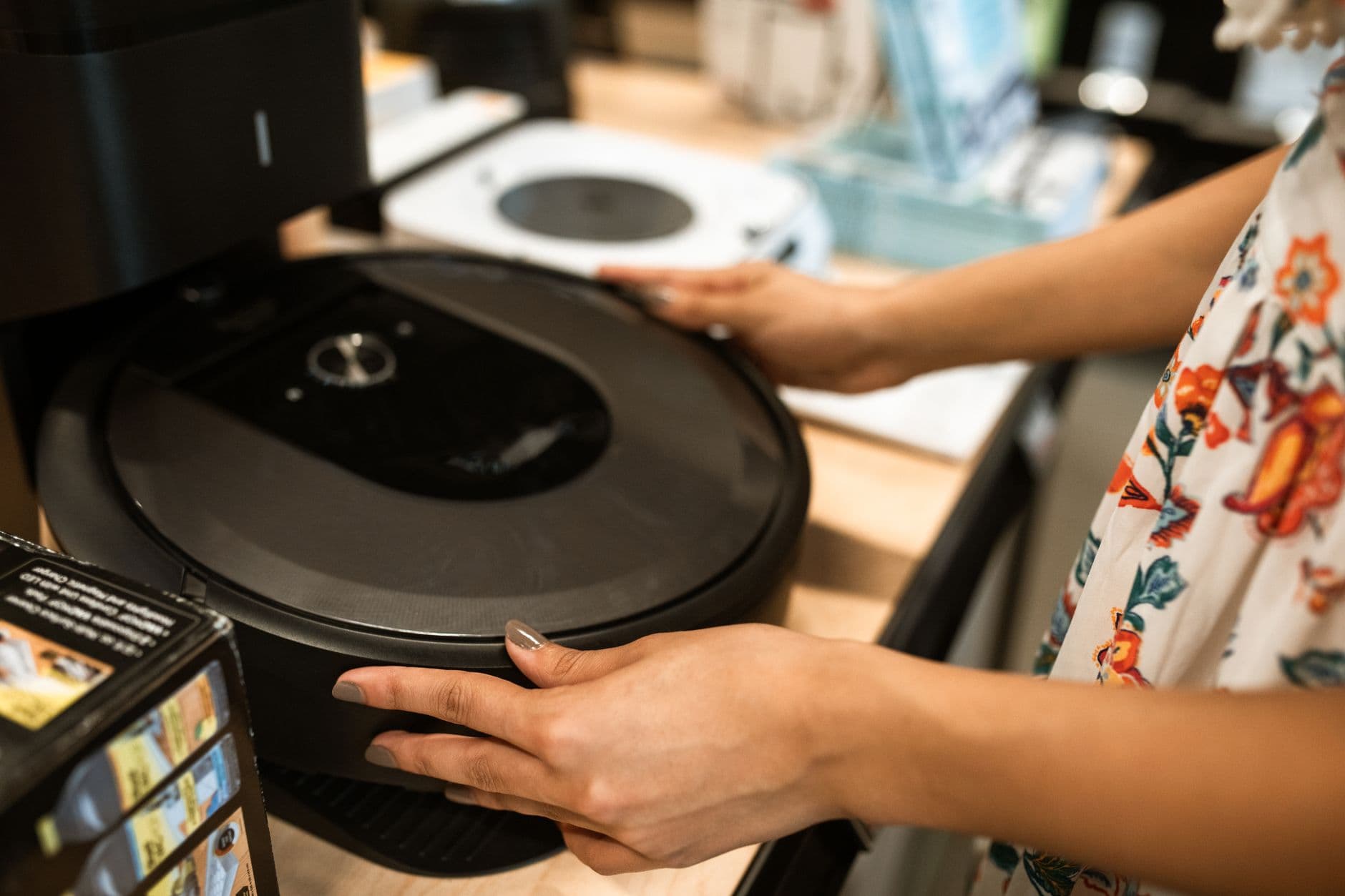 A person examining a robot vacuum cleaner