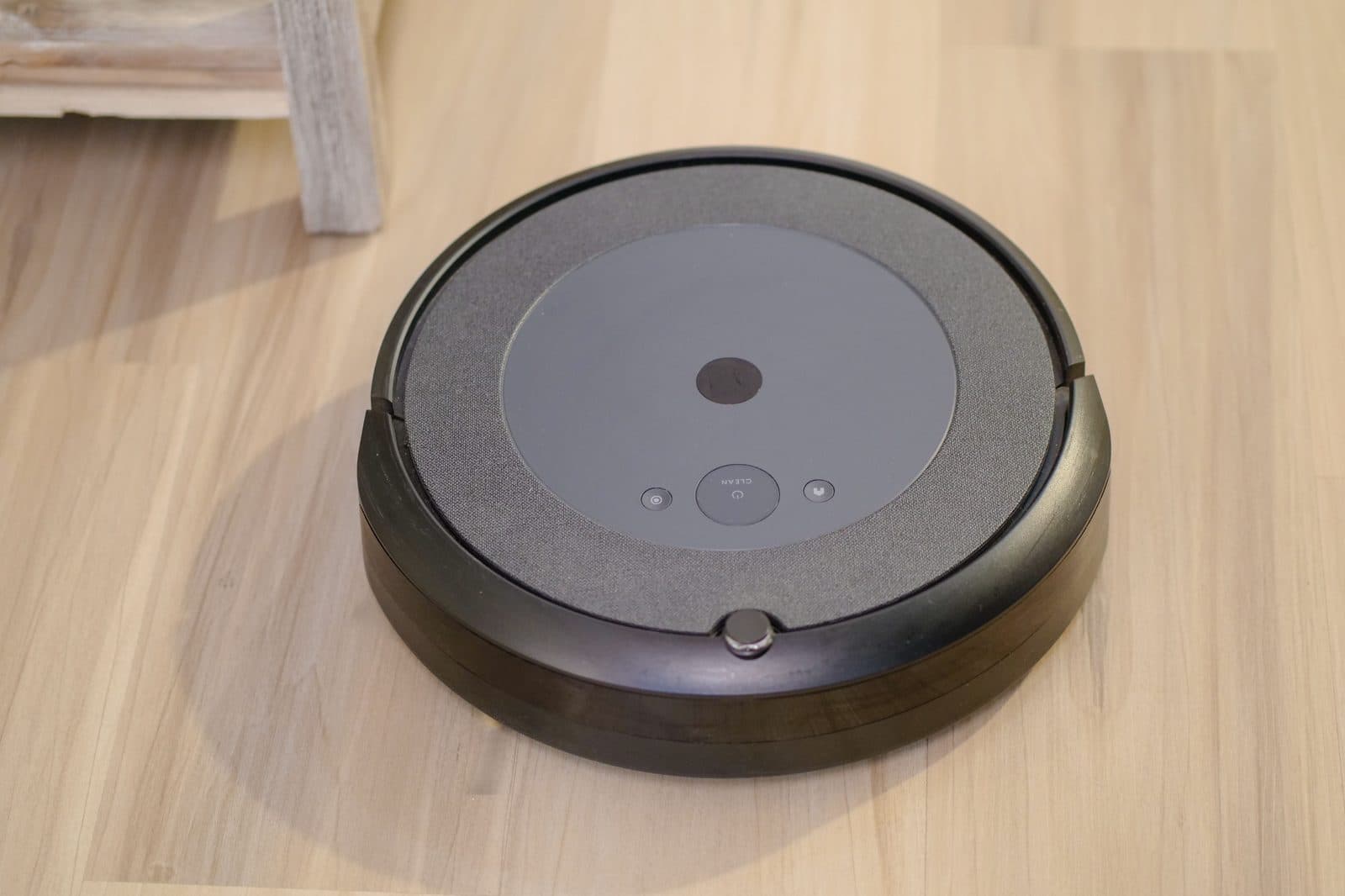 A robot vacuum cleaning a modern floor, seen from above