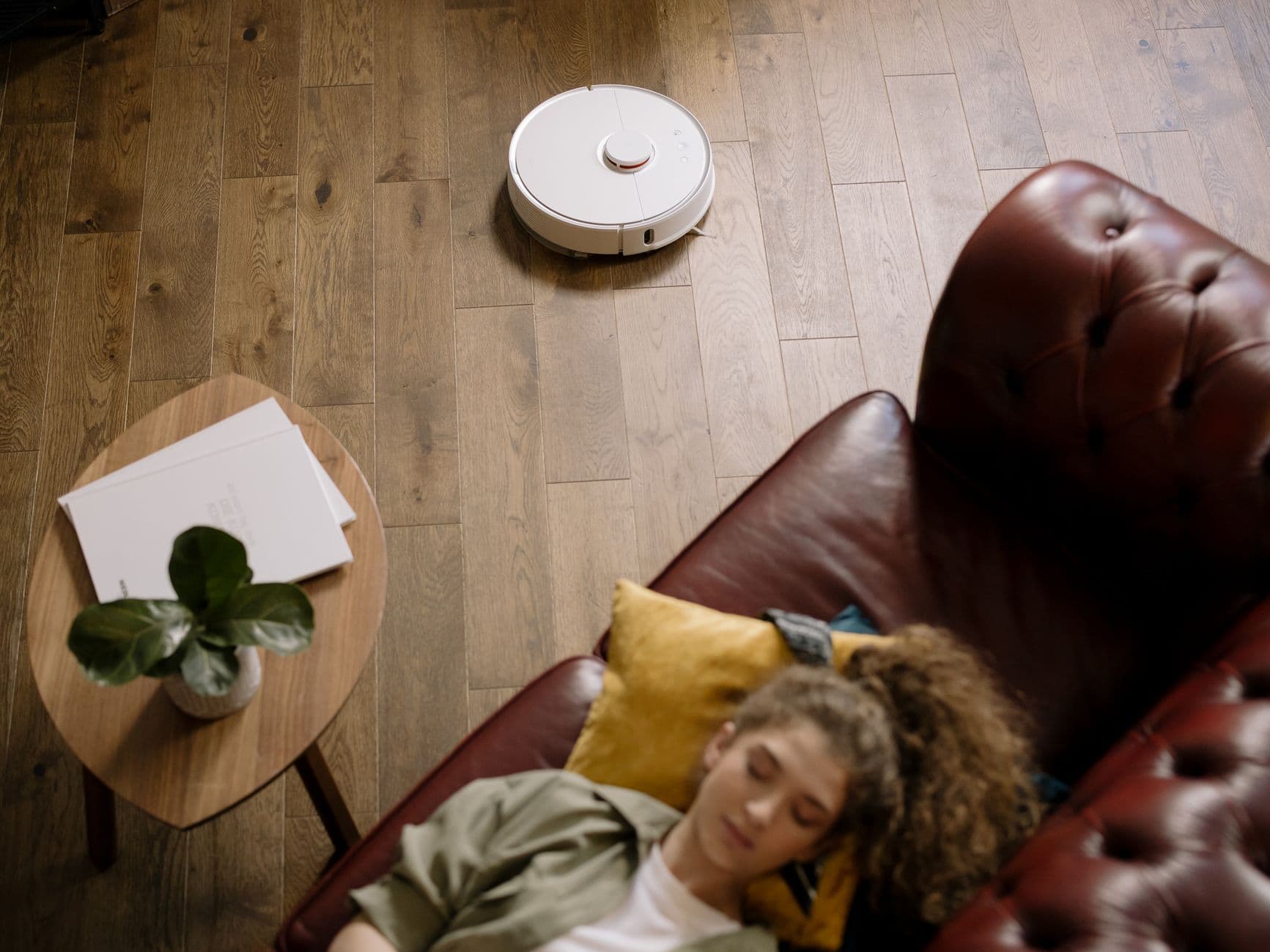 A robot vacuum working across a hardwood living room floor