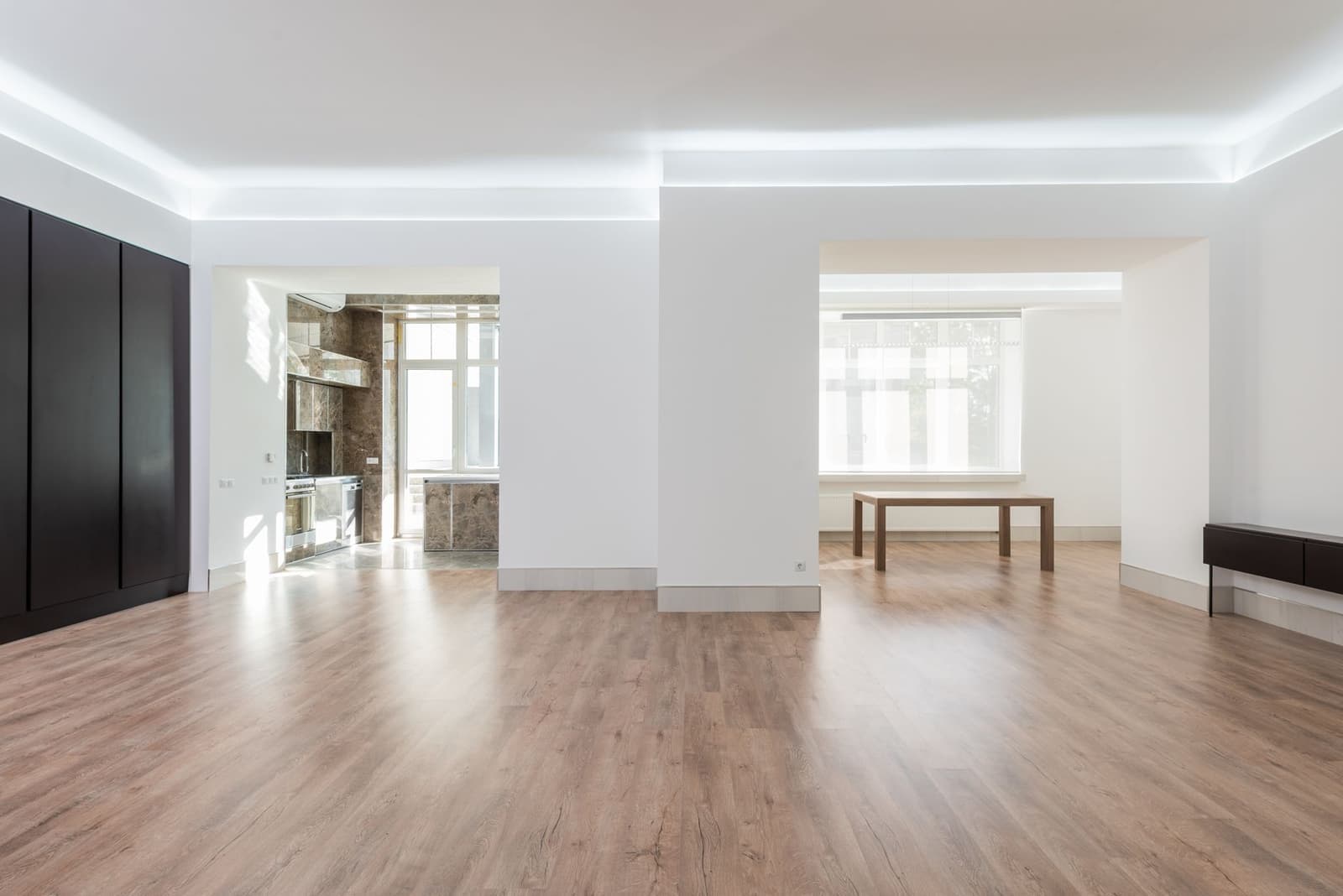 A bright, spacious empty room with wooden flooring