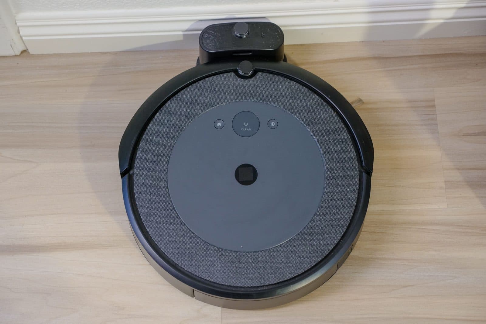 A robot vacuum seen from above on a wooden floor