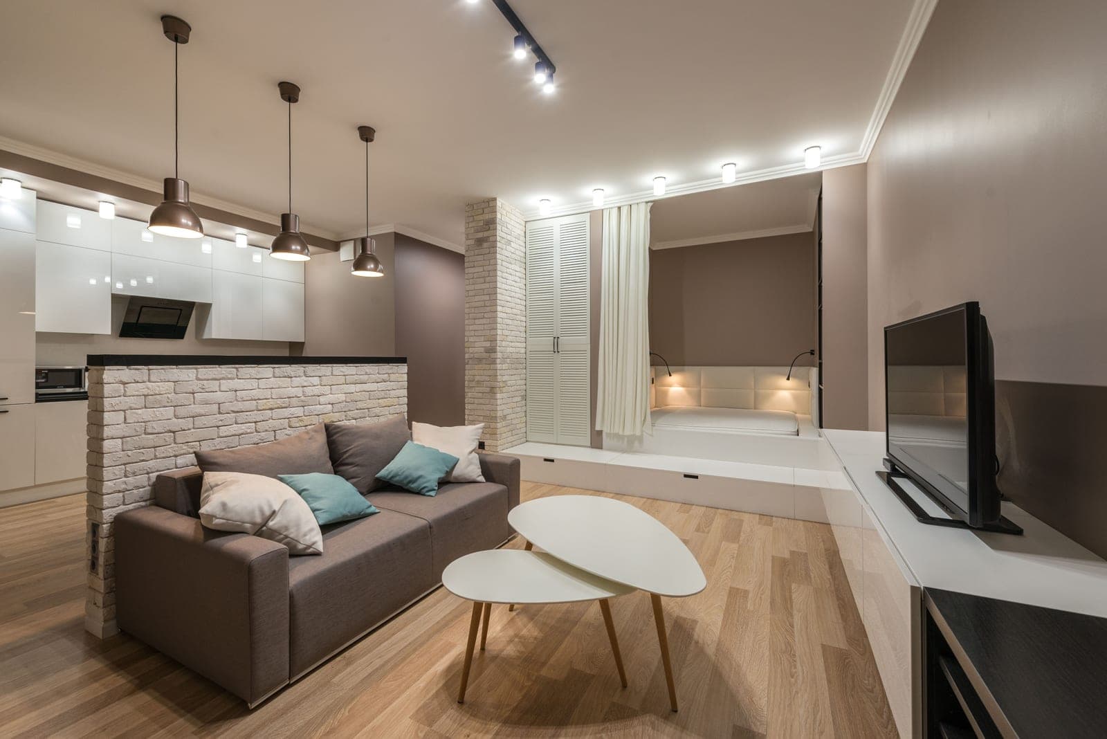 A studio apartment interior with a wooden floor
