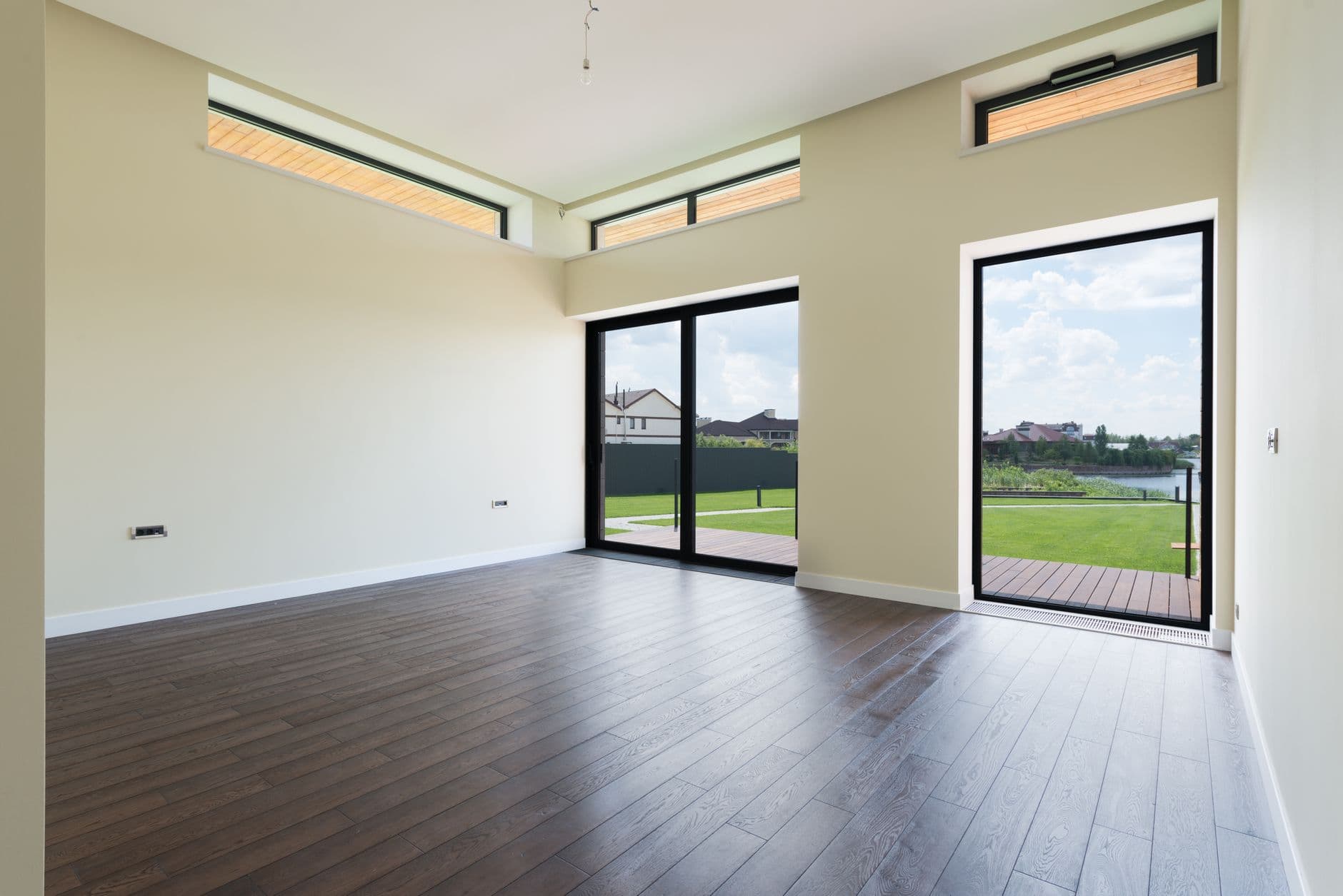 A spacious room with plank flooring and floor-to-ceiling windows