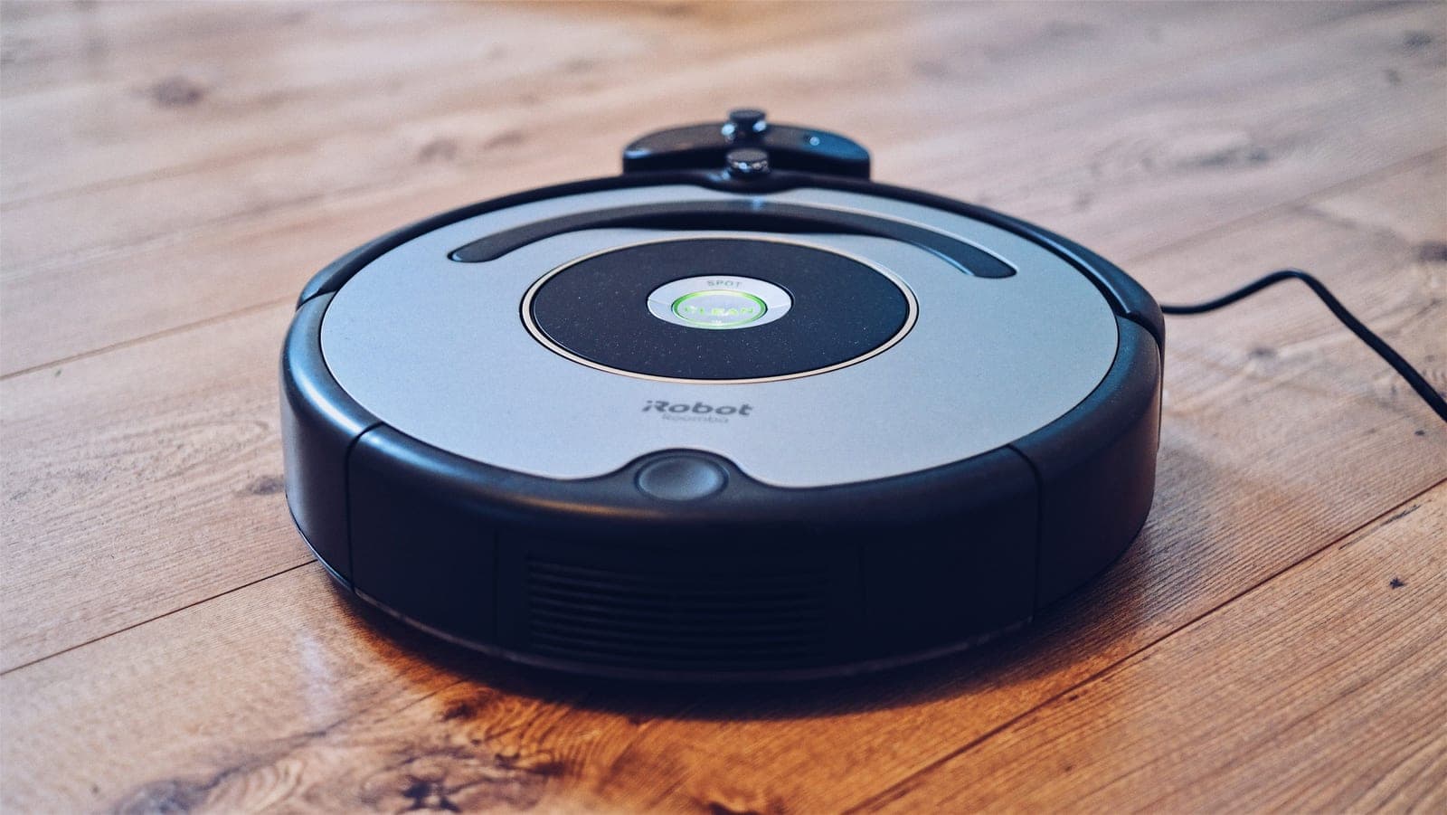 A robot vacuum on a wooden floor in a lived-in room